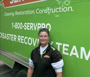 Female employee Terrie Caudle standing in front of a SERVPRO vehicle